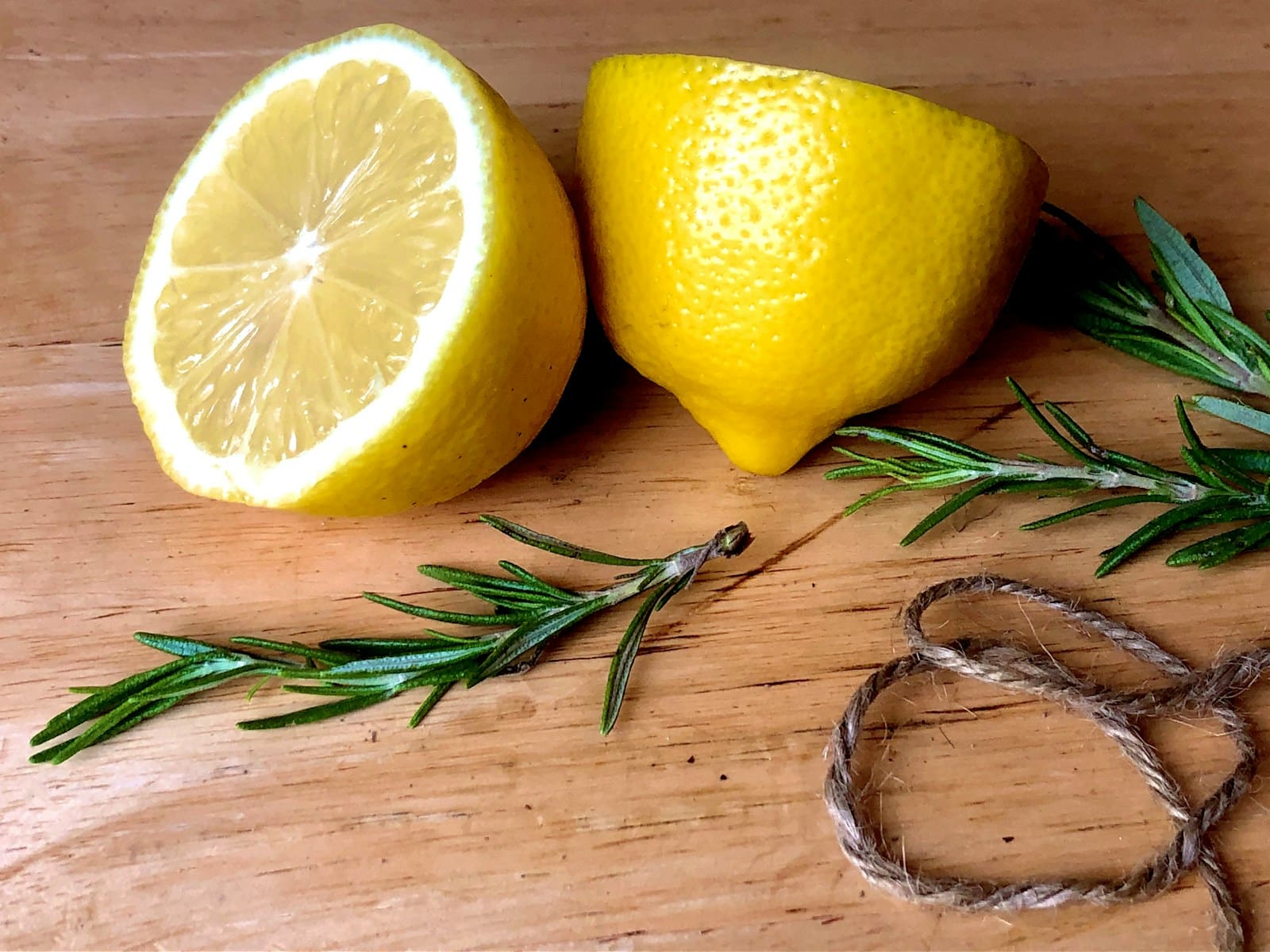 yellow lemon fruit on brown wooden table with rosemary. terpenes are found in many plants