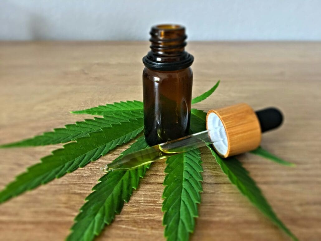 brown tinted glass bottle and dropper on a marijuana leaf with a CBD tincture inside
